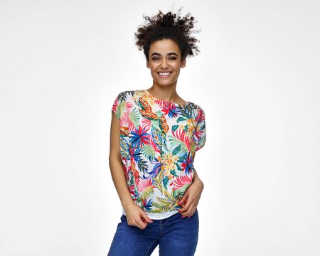 Cheerful latin american woman in colorful t-shirt with afro hairstyle isolated on white backgroundの写真素材
