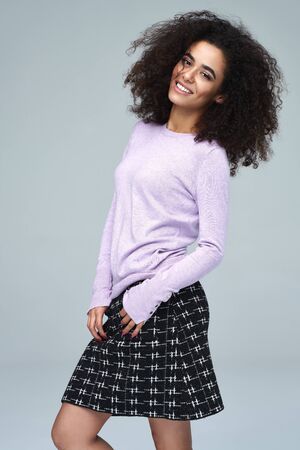 Beautiful latin american woman wear short skirt and smiling at the camera. Isolated on gray backgroundの写真素材