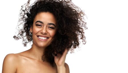 Portrait of beautiful cheerful latin american woman with afro hairstyle looking at camera, isolated on white backgroundの写真素材