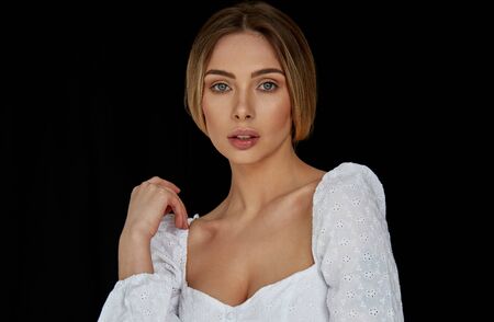 Portrait of sexy blonde woman looking at camera and  isolated on black backgroundの写真素材