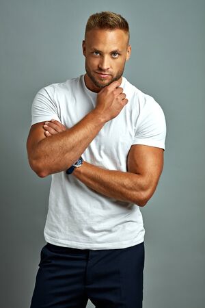 Handsome man touching his beard isolated on gray backgroundの写真素材