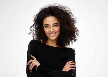 Cheerful latin american woman with afro hairstyle isolated on white backgroundの写真素材