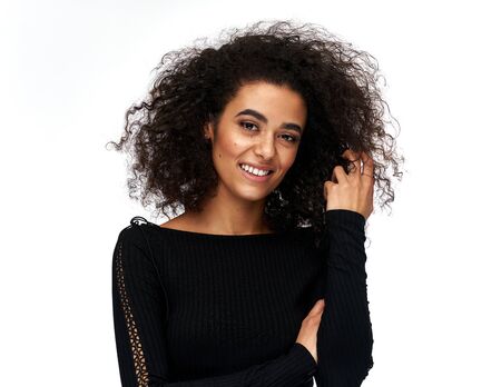 Cheerful latin american woman with afro hairstyle isolated on white backgroundの写真素材