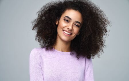 Portrait of beautiful latin american woman smiling at the camera. Isolated on gray backgroundの写真素材