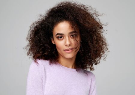 Portrait of beautiful african american woman with afro hairstyle isolated on gray backgroundの写真素材