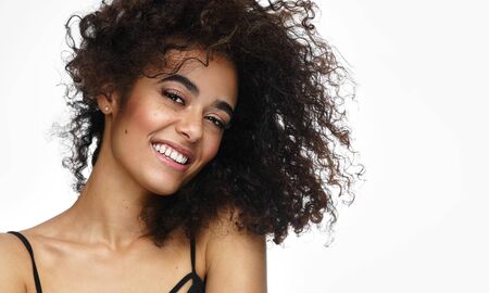 Close up portrait of latin american woman with freckles and afro hairstyle isolated on white backgroundの写真素材