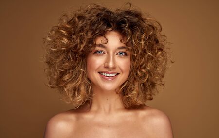 Portrait of cheerful young woman with curly hairの写真素材
