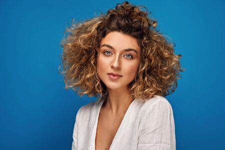 Portrait of young woman with blonde curly hairの写真素材