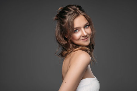 Portrait of a young woman isolated on gray background