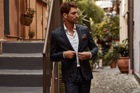 Young handsome man in classic suit with checked pattern buttoningの写真素材