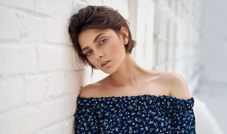 Beauty portrait of female face with natural clean skin and short hair on white wallの写真素材