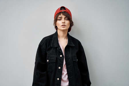 Portrait of young woman in a Cap wear denim jacket over gray backgroundの写真素材
