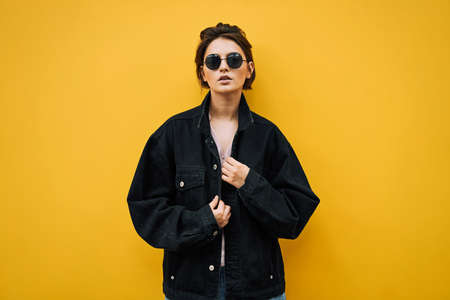 Fashion woman in sunglasses isoalted on yellow backgroundの写真素材