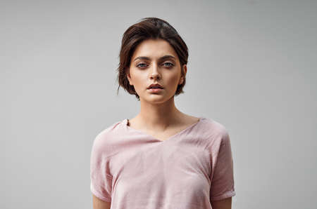 Beautiful woman with natural make-up and short hair on gray backgroundの写真素材
