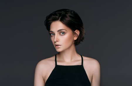 Studio shoot of fashionable brunette woman with short stylish hair looking at cameraの写真素材