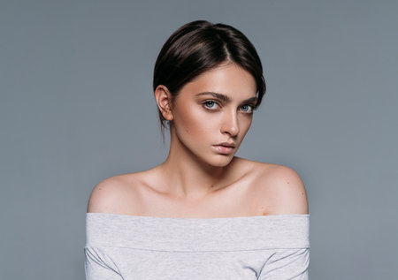 Studio shoot of young sensual brunette woman with short hair isolated on gray backgroundの写真素材