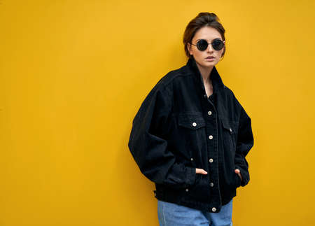 Vintage photo of young woman in sunglasses and black jacketの写真素材