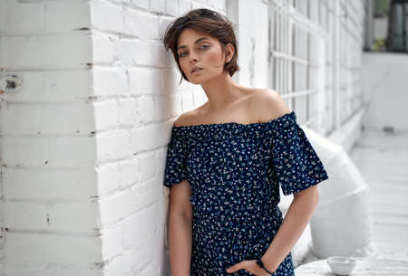 Beauiful woman with natural clean skin and short hair wear summer dress on white wallの写真素材