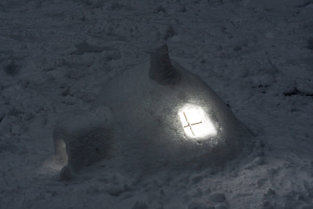 Miniature igloo from the snow in the evening in the forest in which the light is on