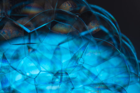 Blue soap bubbles with blue glow and rainbow fire reflections in them