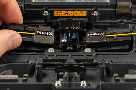 optical fiber welding workflow, stacking holders in a welding machine, close-upの写真素材
