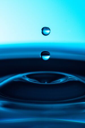 Two blue drops on a blue background with blue waterの写真素材