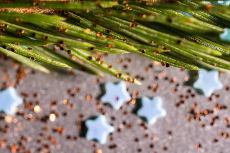 Spruce branch on a silver background and sparkles and confectionery starsの写真素材