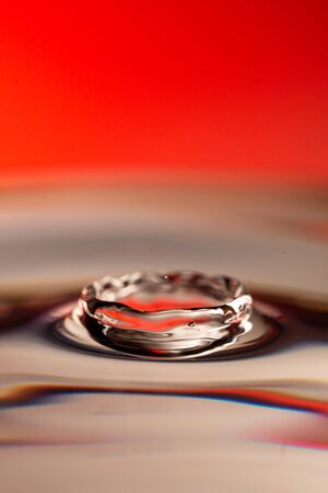 Silver mercury crater on a red backgroundの写真素材