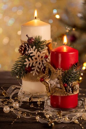 Two christmas candles red and white on the background of the Christmas treeの写真素材