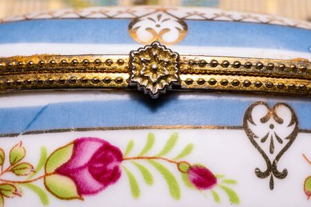 old blue and white painted ceramic jewelry box with metal golden handle macroの写真素材