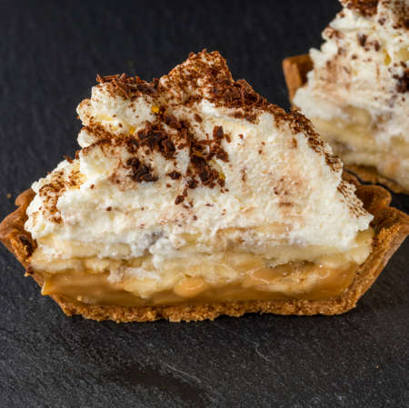 banoffi pie with white cream and chocolate chips, close-up on a stone trayの写真素材
