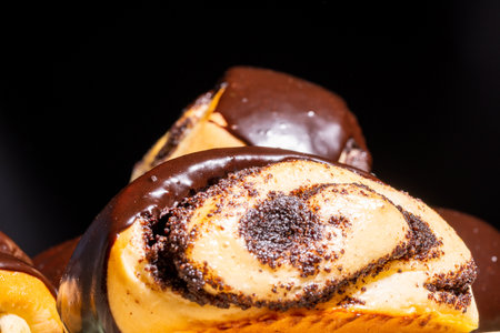 Rolled buns with poppy seeds, covered with chocolate icing, close-up.の写真素材