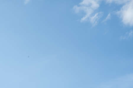 Blue sky with clouds and planeの写真素材