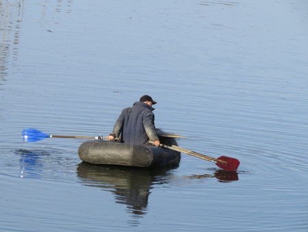 Fisherman floats on a rubber boat and fishing.