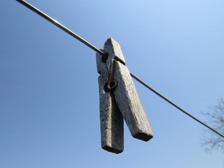 Clothespins on a clothesline in front of blue sky.の写真素材