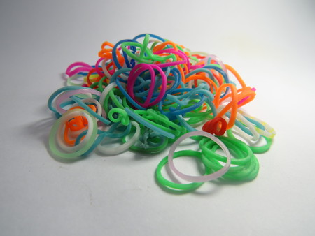 Loom bands of different colors on a white background.の写真素材