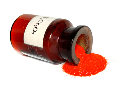 Orange powder, potassium dichromate, poured out of the jar.の写真素材