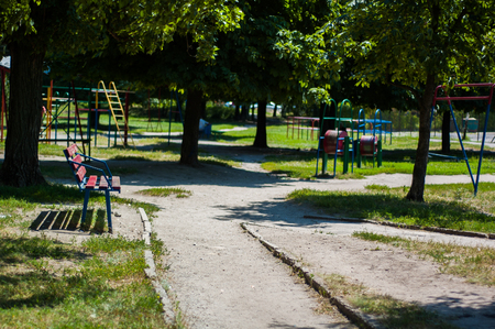 Bench in the park in the summer on a background of trees and swing.の写真素材
