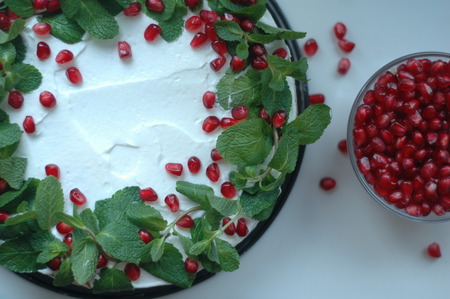 Sponge cake with white cream, mint and berries pomegranate.の写真素材