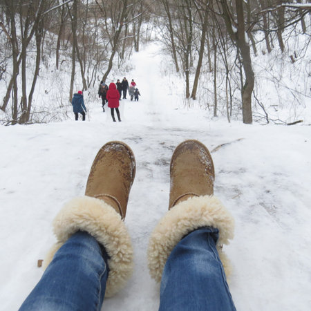 The legs of the girl, slides down the sled.