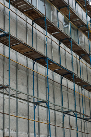 Old metal scaffolding near a tall building.の写真素材