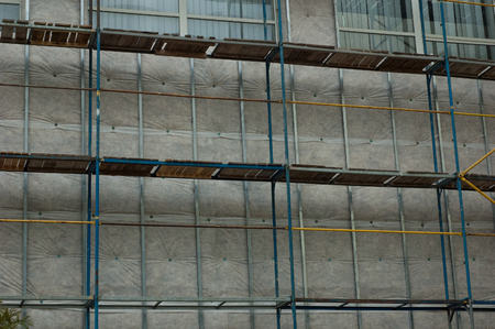Old metal scaffolding near a tall building.の写真素材