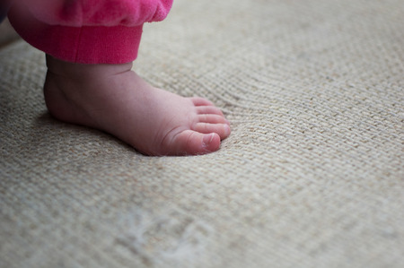 The legs of a little girl close-up on a neutral background.の写真素材