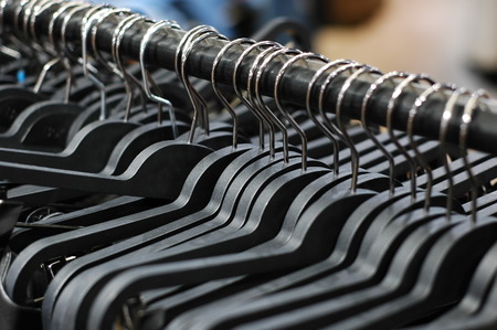 A lot of hangers on the shelf in the store.の写真素材