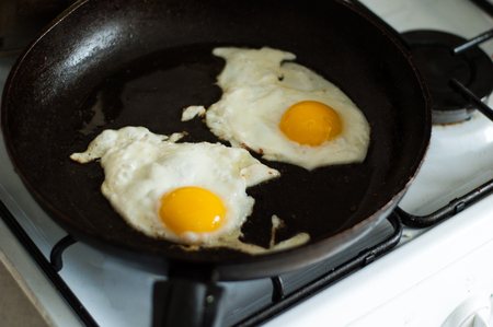 Two fried eggs in a frying pan.の写真素材