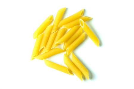 A lot of raw macaroni on a white background.の写真素材