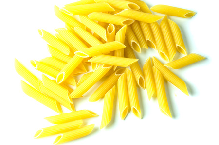 A lot of raw macaroni on a white background.の写真素材