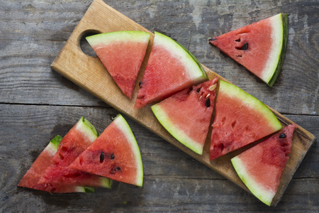 Several pieces of ripe watermelon on a wooden surface.の写真素材