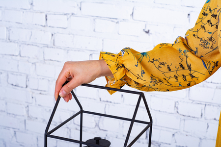 The hand of a girl with a sleeve of a yellow dress on a metal stand.の写真素材