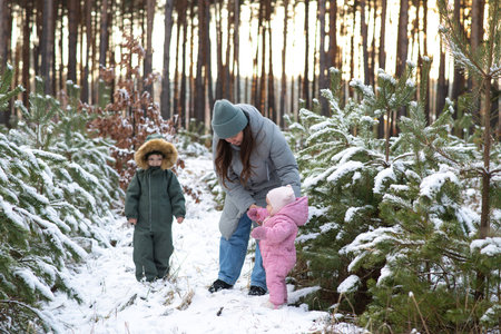 Winter fun: family playing and exploring a snowy forestの写真素材